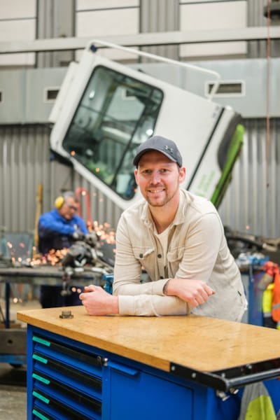 Foto van een ROVA-medewerken in een garage waar aan een vrachtwagen wordt gewerkt